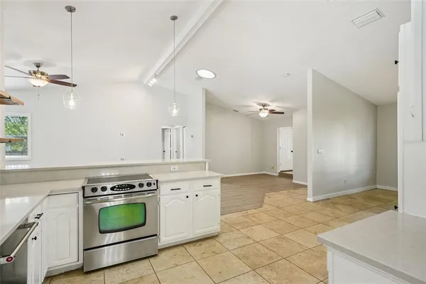 a large white kitchen with granite countertop a sink