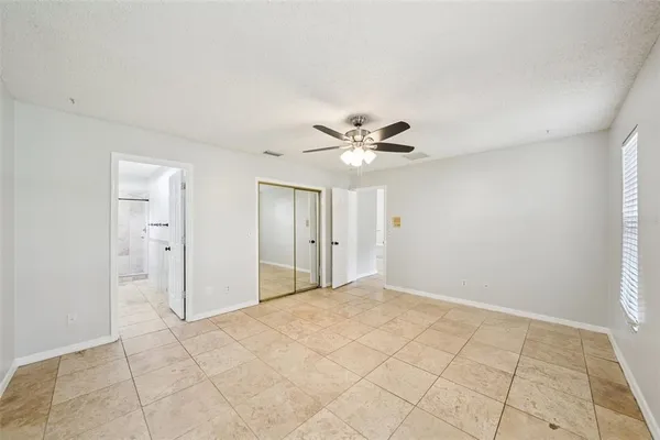 a view of a room with wooden floor and a ceiling fan
