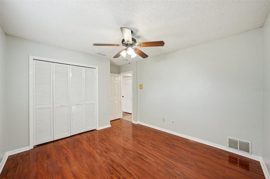 3109 Lake Valencia Lane East Palm Harbor, FL 34684 - Photo 25 of 59 a view of a room with wooden floor and a ceiling fan