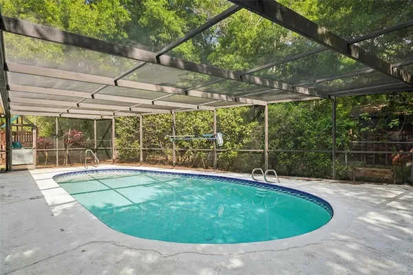 a view of a backyard with a slide and a wooden fence