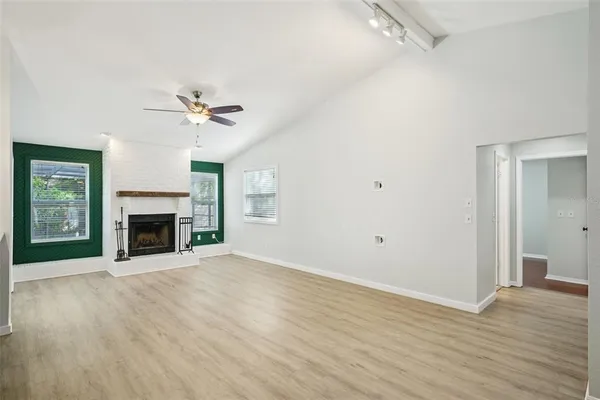 a view interior of a kitchen with a fireplace a ceiling fan and wooden floor
