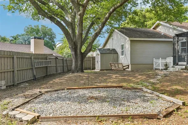 a view of house with a big yard plants and large trees