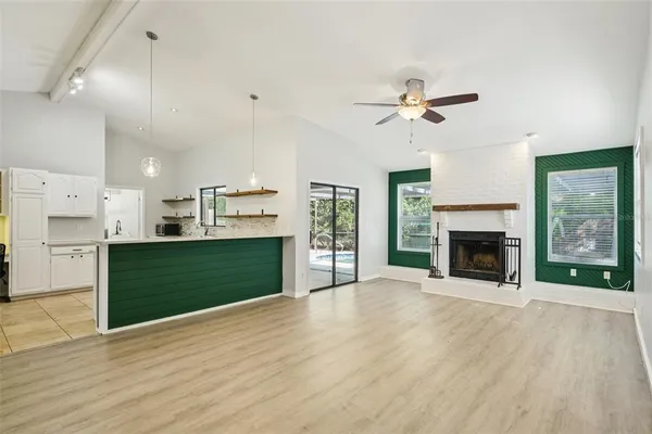 a view of an empty room with window and wooden floor