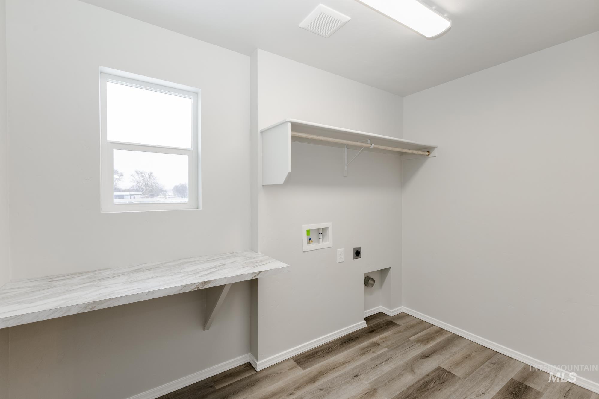 13712 Nisene Street Caldwell, ID 83607 - Photo 18 of 23 Laundry area featuring light wood finished floors, electric dryer hookup, and hookup for a washing machine