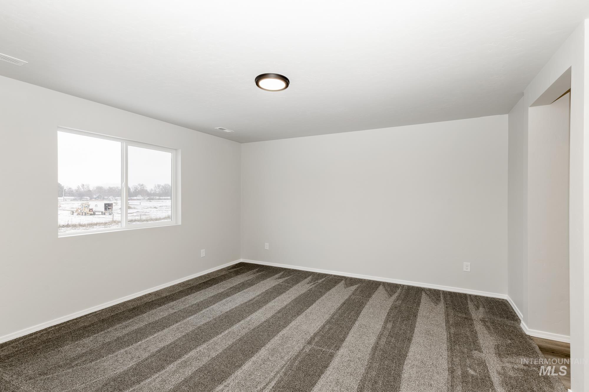 13712 Nisene Street Caldwell, ID 83607 - Photo 19 of 23 Empty room with dark colored carpet and baseboards