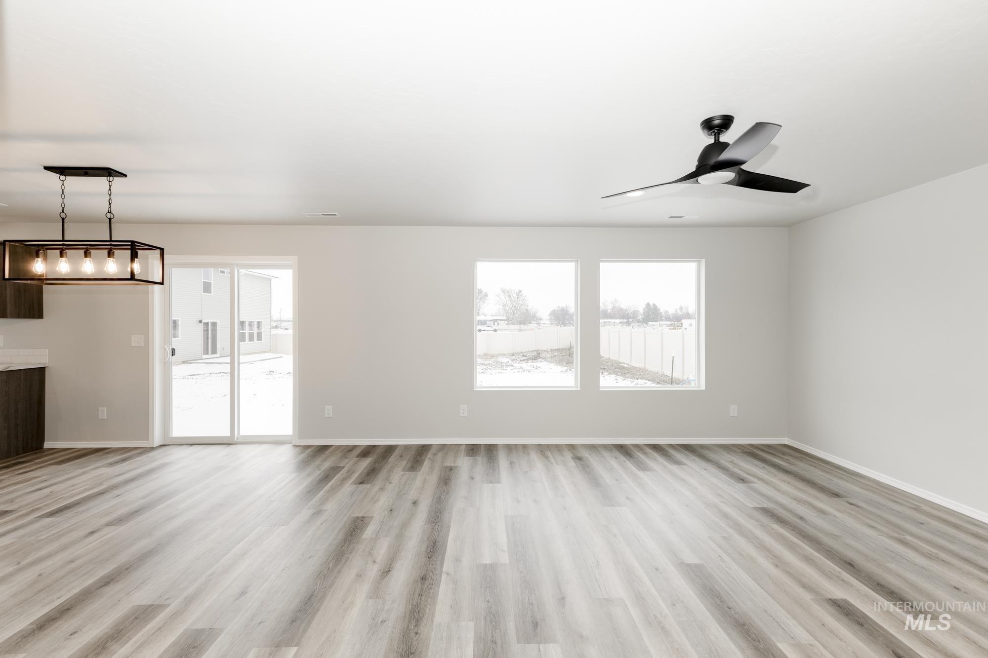 13712 Nisene Street Caldwell, ID 83607 - Photo 7 of 23 Unfurnished living room featuring light wood-style floors and a ceiling fan
