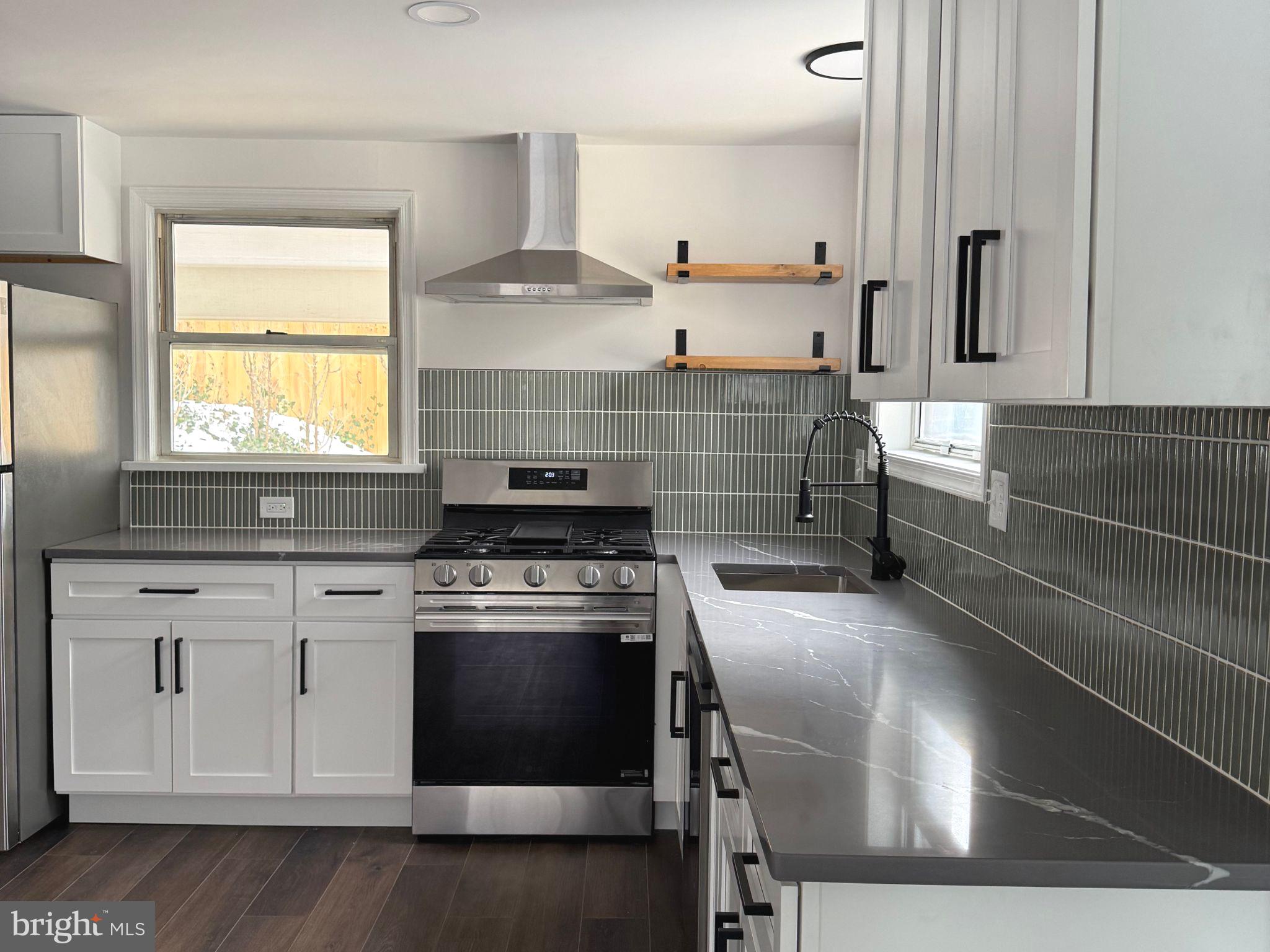 a kitchen with a stove and white cabinets