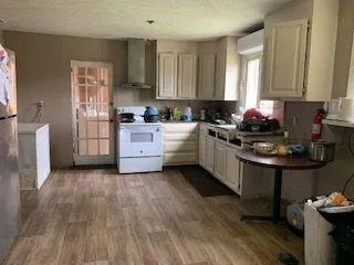 a kitchen with stainless steel appliances a stove a sink dishwasher and cabinets with wooden floor