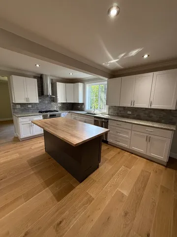 a large kitchen with stainless steel appliances granite countertop a stove and a sink