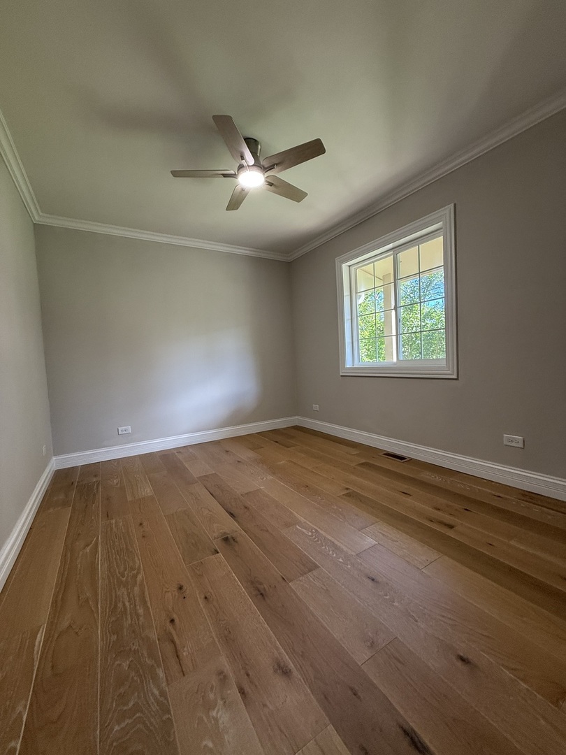 8144 Sunset Road Willowbrook, IL 60527 - Photo 7 of 8 an empty room with wooden floor fan and windows