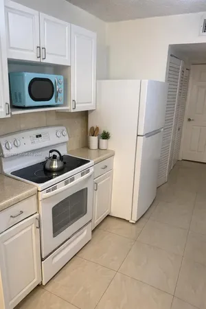 a kitchen with a refrigerator sink and cabinets