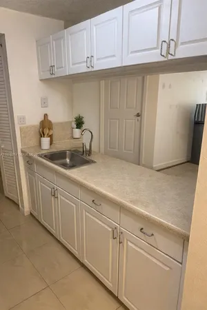 a kitchen with white cabinets and white appliances