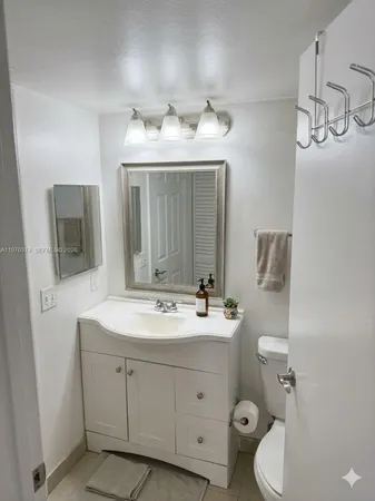 a bathroom with a toilet sink and mirror