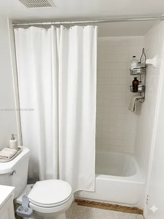 a white toilet sitting next to a shower curtain
