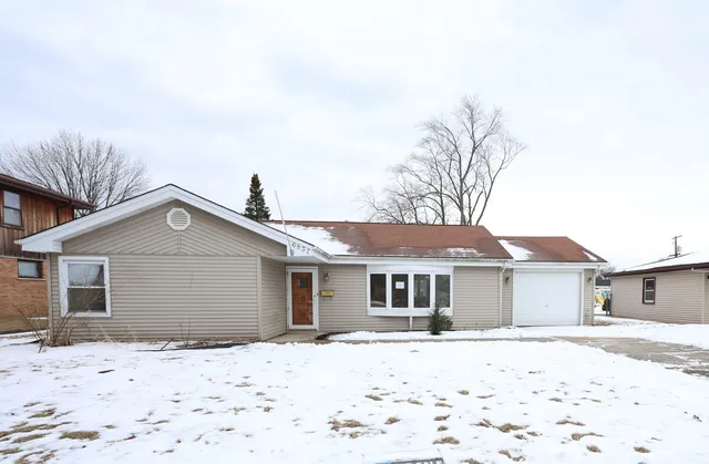 a front view of a house with a yard covered in snow