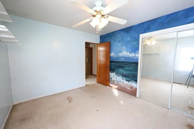 an empty room with a window and a ceiling fan