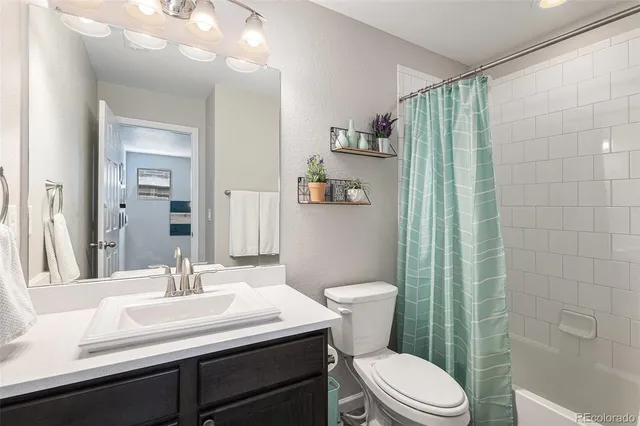 a bathroom with a sink a toilet a mirror and shower