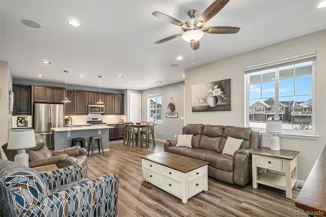 a living room with furniture kitchen view and a large window