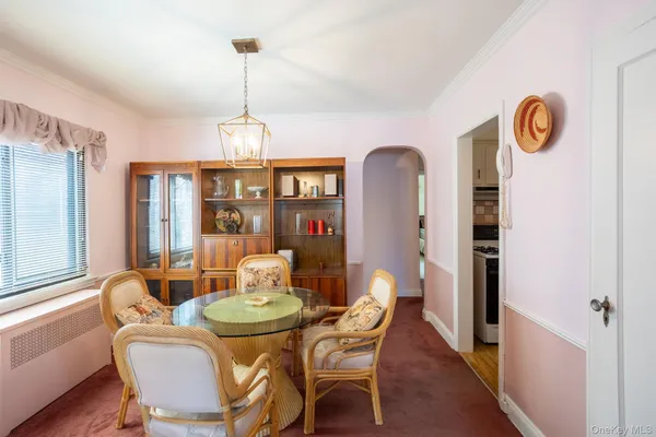 a dining room with furniture a chandelier and wooden floor
