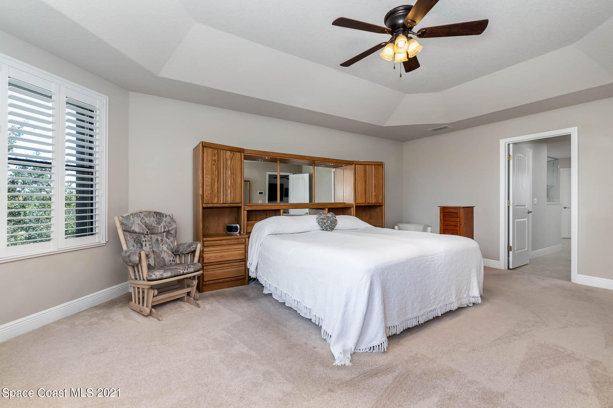 4175 Waterloo Place Melbourne, FL 32940 - Photo 24 of 49 a bedroom with a bed and a chandelier