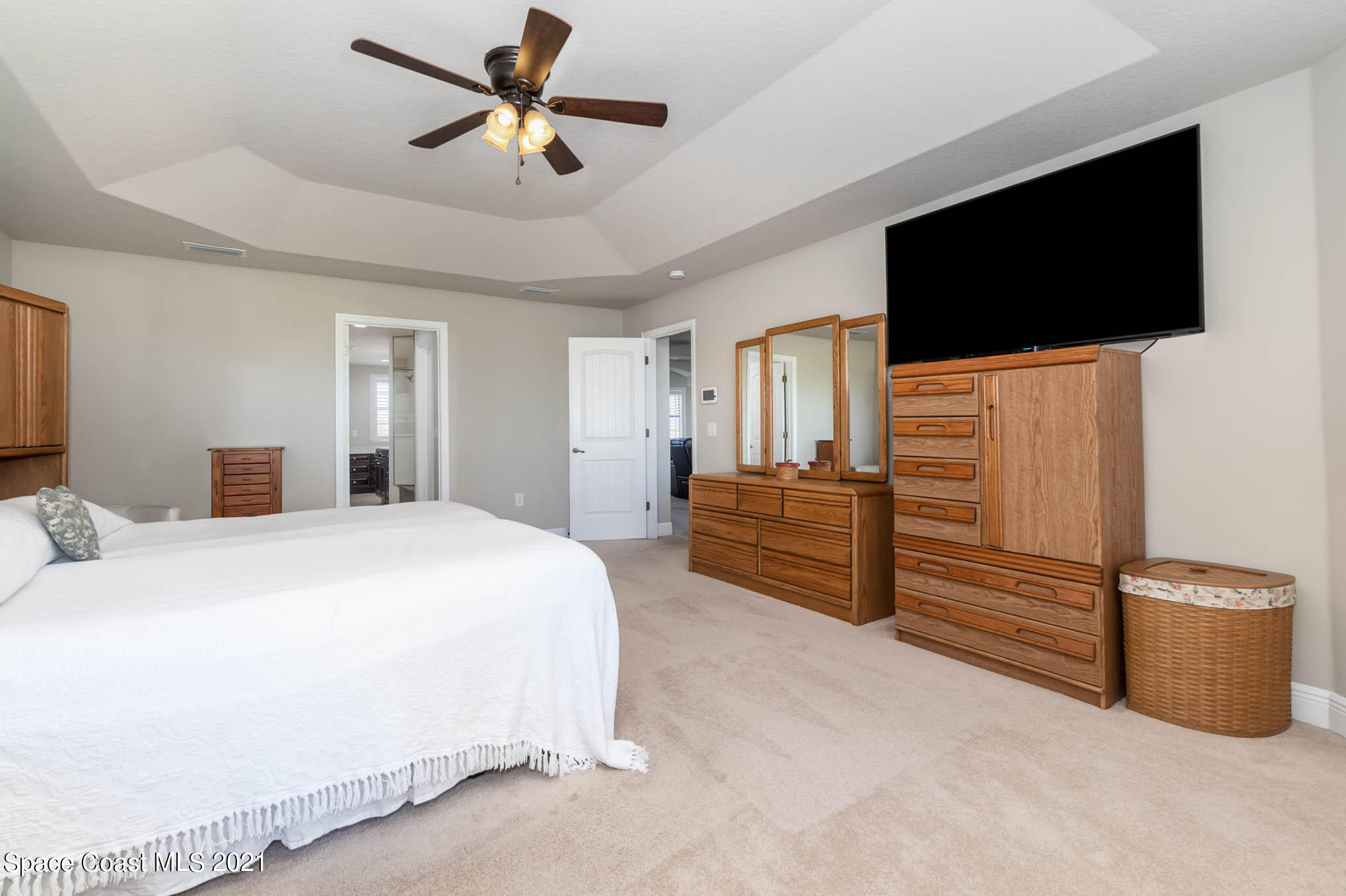 4175 Waterloo Place Melbourne, FL 32940 - Photo 25 of 49 a spacious bedroom with a bed and a flat screen tv