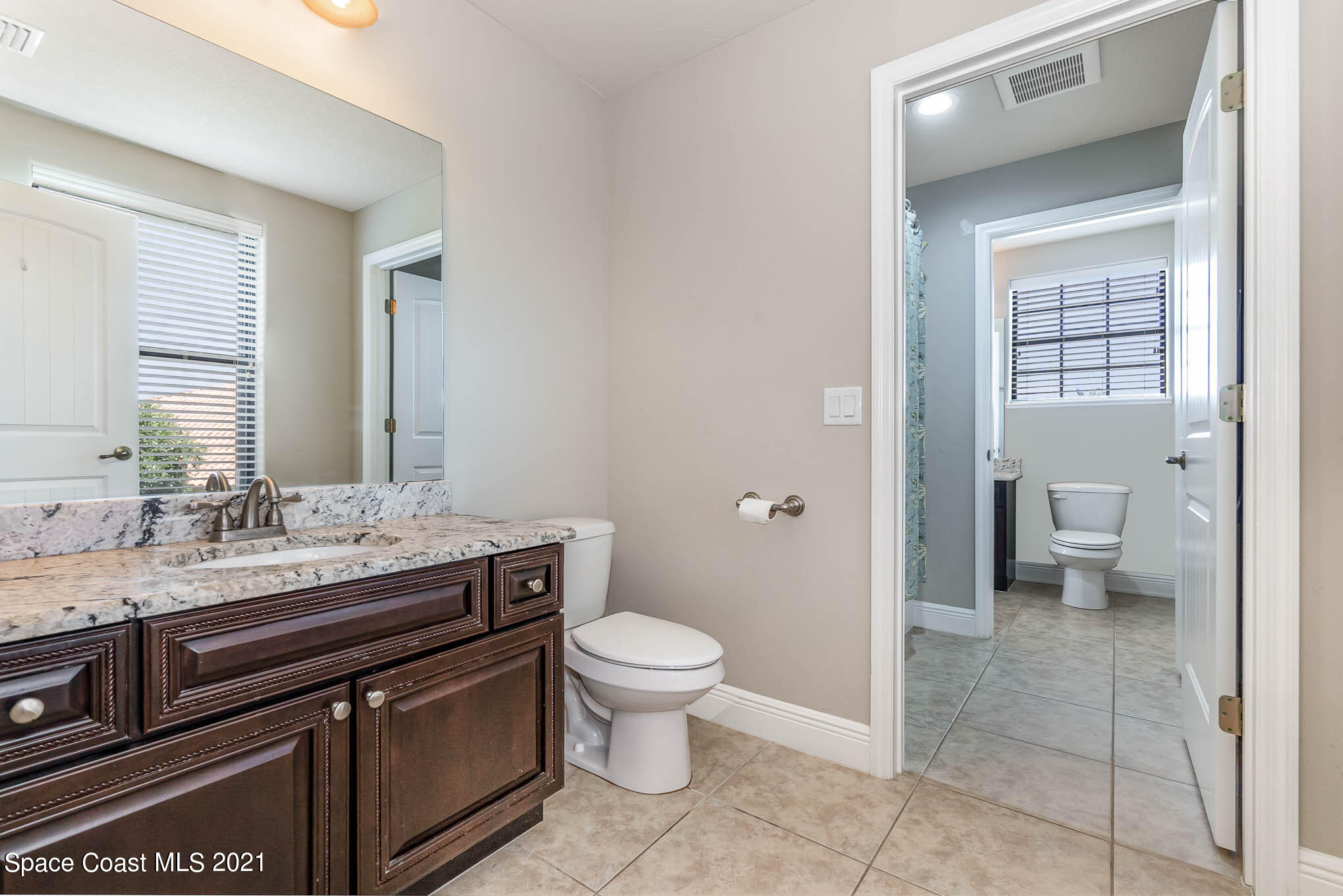 4175 Waterloo Place Melbourne, FL 32940 - Photo 34 of 49 a bathroom with a granite countertop sink a toilet and a mirror