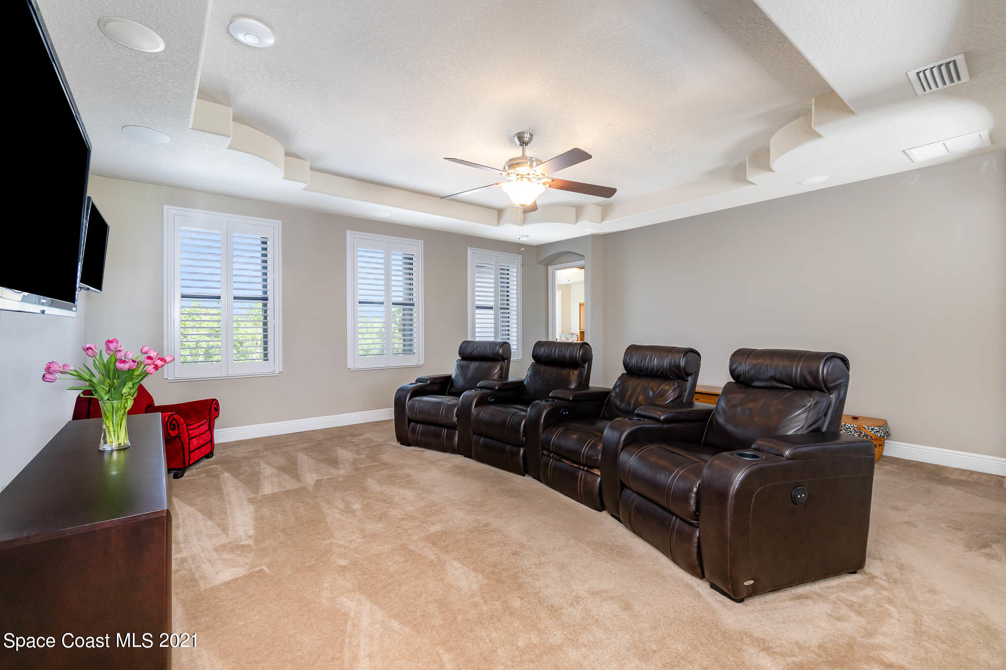 4175 Waterloo Place Melbourne, FL 32940 - Photo 38 of 49 a living room with furniture a flat screen tv and a chandelier