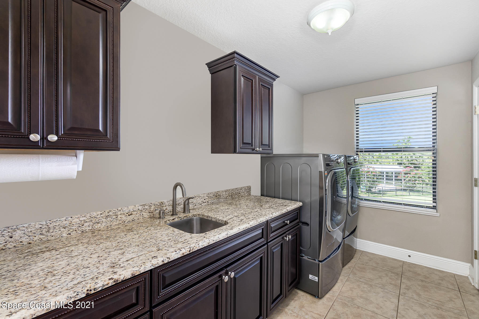4175 Waterloo Place Melbourne, FL 32940 - Photo 48 of 49 a kitchen with granite countertop a sink a stove and cabinets