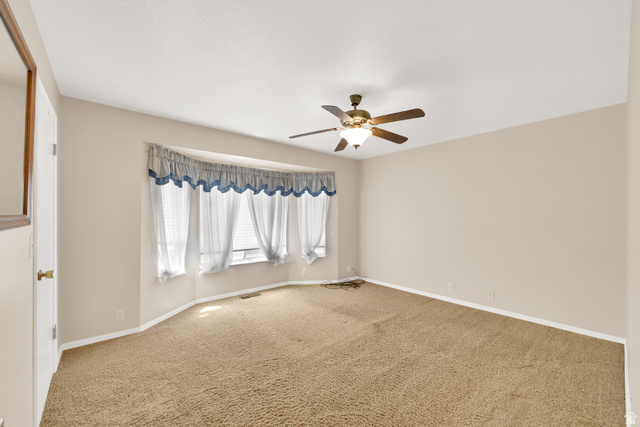 8029 Angel Street Sandy, UT 84070 - Photo 10 of 21 Spacious room featuring a multi-pane bay window, neutral wall paint, and a ceiling fan with integrated lighting