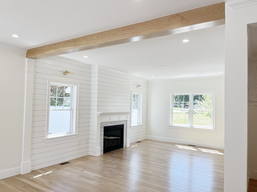 18 Libby Avenue Reading, MA 01867 - Photo 15 of 23 an empty room with wooden floor windows and fireplace