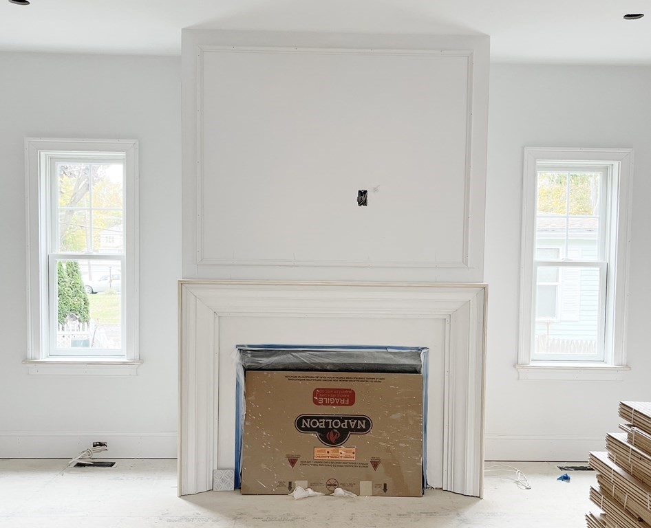18 Libby Avenue Reading, MA 01867 - Photo 9 of 23 a living room with a fireplace and windows