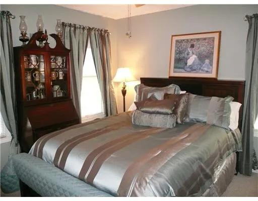 a bedroom with a bed and a painting on the wall