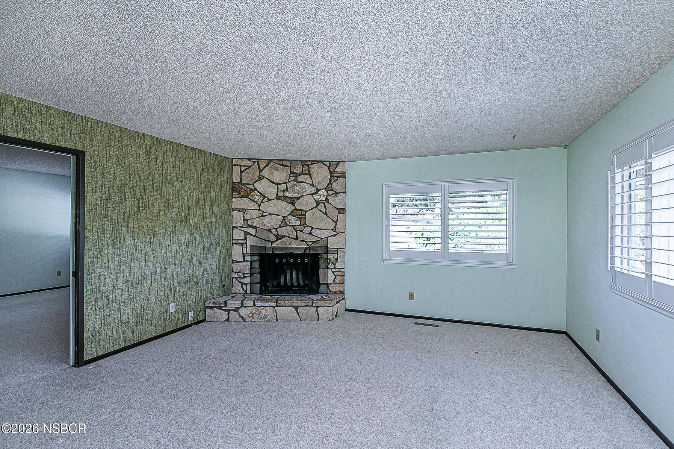 1260 Onstott Road Lompoc, CA 93436 - Photo 12 of 52 an empty room with a fireplace and window