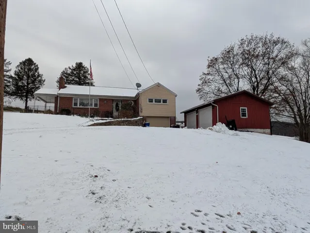 a front view of a house with a yard covered in snow