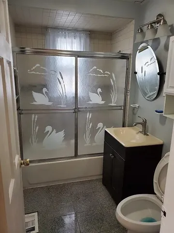 a bathroom with a sink mirror vanity and toilet