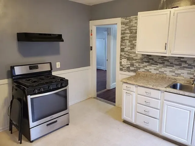 a kitchen with granite countertop white cabinets and appliances