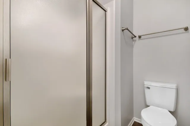a white toilet sitting next to a shower