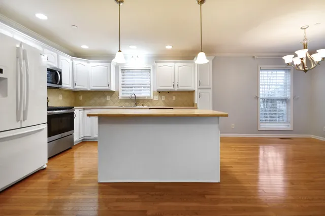 a kitchen with kitchen island a sink stainless steel appliances and cabinets