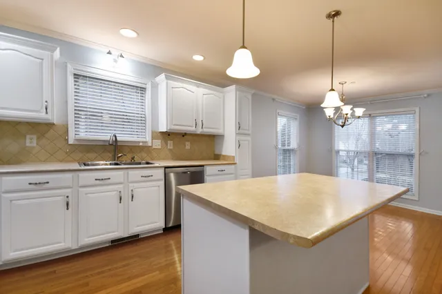 a kitchen with granite countertop a sink cabinets and wooden floor