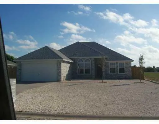 a front view of house with yard and garage