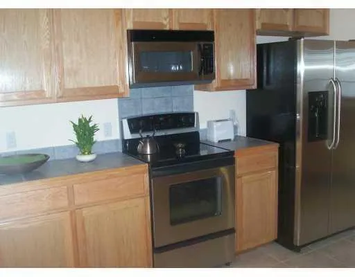 a kitchen with stainless steel appliances granite countertop a refrigerator a stove a microwave oven with white cabinets