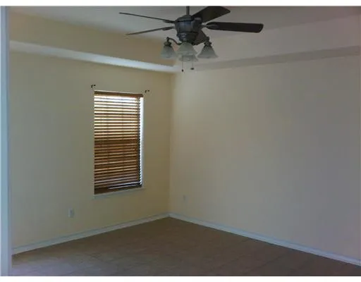 an empty room with a window and a fan