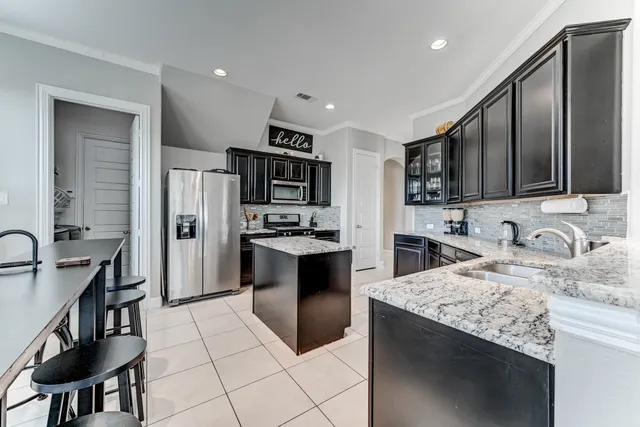 a kitchen with stainless steel appliances granite countertop a refrigerator stove microwave and sink