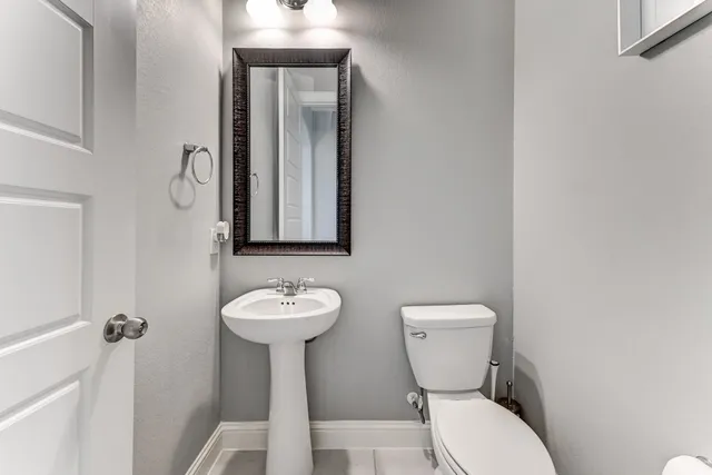 a bathroom with a toilet sink and mirror