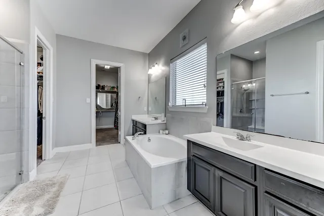 a spacious bathroom with a bathtub sink and mirror