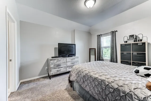 a bedroom with a bed and a television