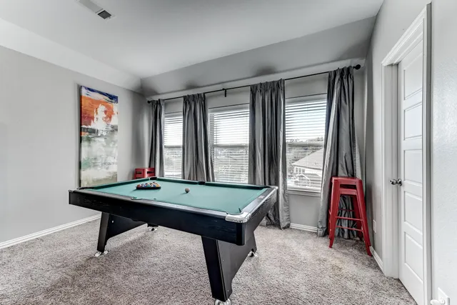 a room with pool table and windows