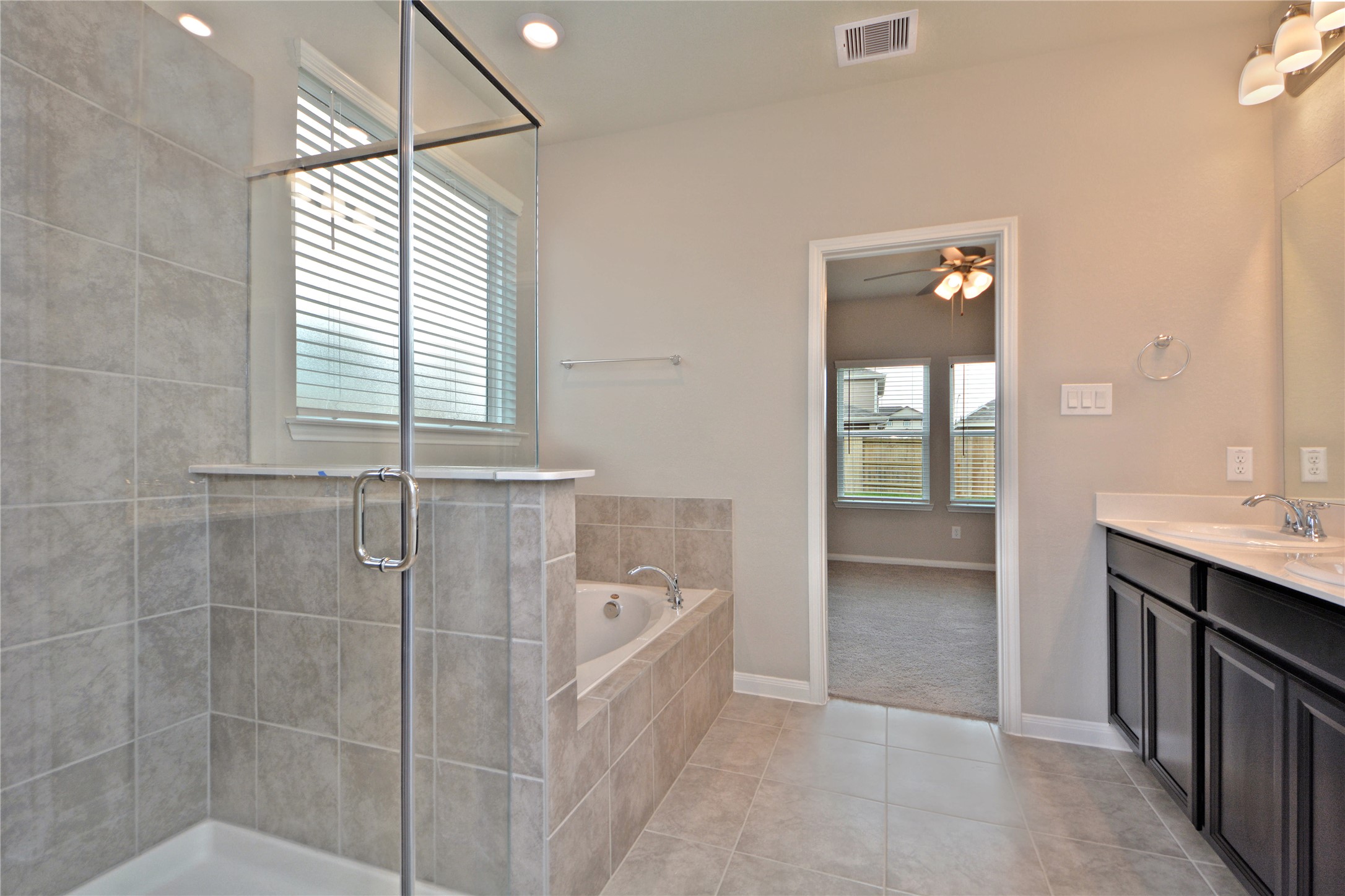 1015 Modesto Drive Rosharon, TX 77583 - Photo 20 of 37 Spa like primary bathroom featuring elegant finishes, soaking tub, and a large separate seamless glass enclosed shower! Enjoy a bright and airy space designed for relaxation and everyday luxury. A true retreat within your home!