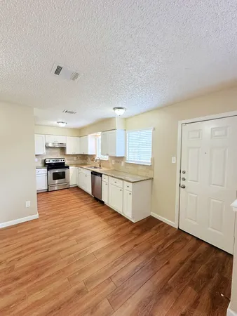 a large kitchen with stainless steel appliances granite countertop a stove and a refrigerator