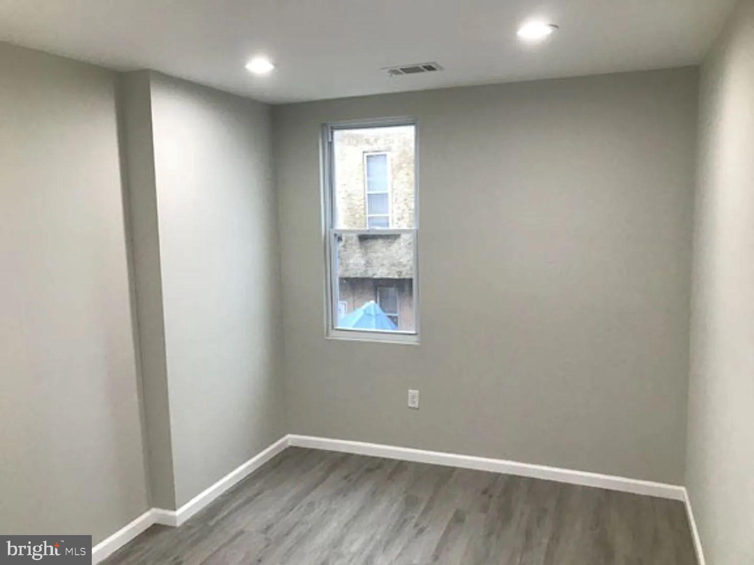 228 South Edgewood Street Philadelphia, PA 19139 - Photo 12 of 15 a view of an empty room with wooden floor and a window